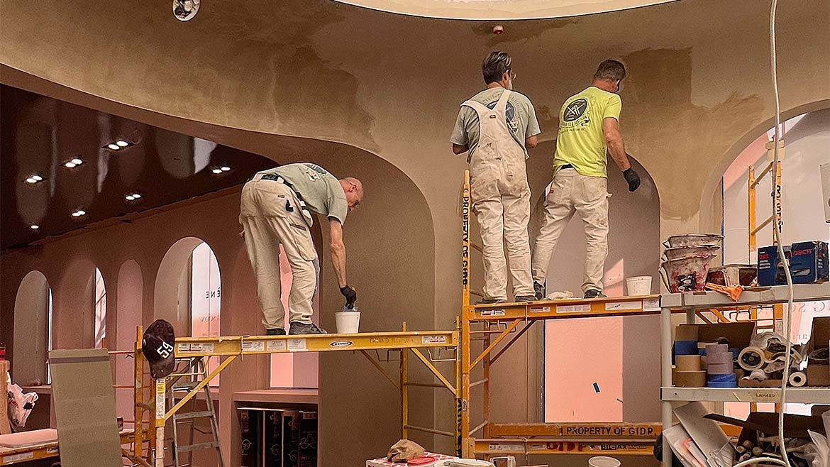 A work crew applying plaster