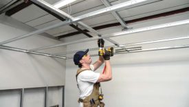 A man installing a QuickSpan Locking Drywall Grid System