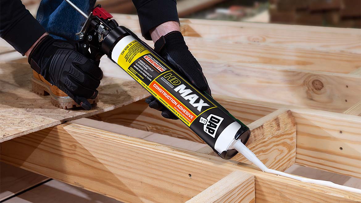 A worker using caulk gun to apply Hybrid Construction Adhesive