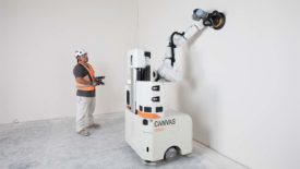 A man standing next to a drywall finishing machine