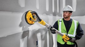 A man using DeWalt's Cordless Drywall Sander